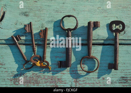 Skeleton keys on top of a wooden surface. Vintage and retro themed photograph Stock Photo