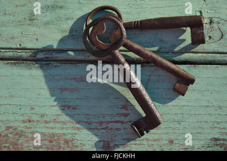 Skeleton keys on top of a wooden surface. Vintage and retro themed photograph Stock Photo