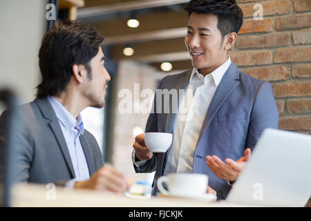 Chinese businessmen working with laptop in café Stock Photo
