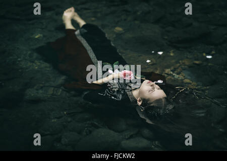 Beautiful floating dead woman in water . Ophelia conceptual Stock Photo