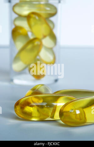 fish oil capsules, clear bottle in background Stock Photo