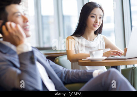 Young Chinese woman working with laptop in café Stock Photo