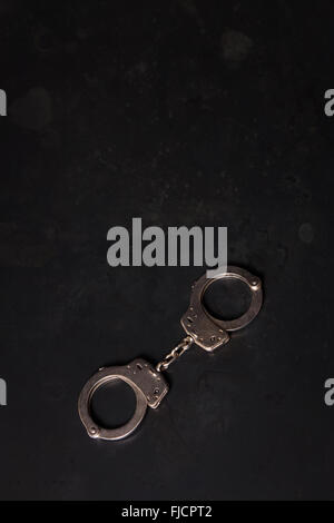 Handcuffs on a black background. Stock Photo