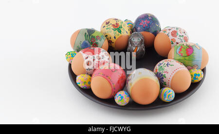 Easter eggs and chocolate bunny on black plate and white background Stock Photo