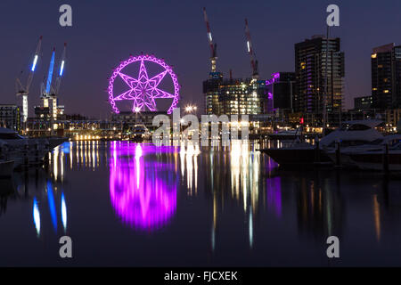 Melbourne, Australia - Feb 21 2016: Observation wheel lit in purple in Docklands, Melbourne with reflections in Yarra river. Nig Stock Photo