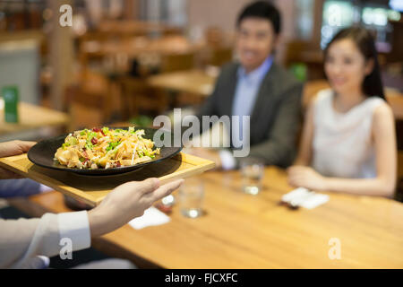 Chinese waitress serving in restaurant Stock Photo