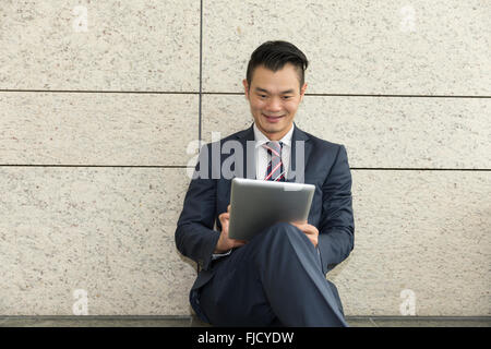 Chinese man with a tablet computer. Asian business man using digital tablet computer. Stock Photo