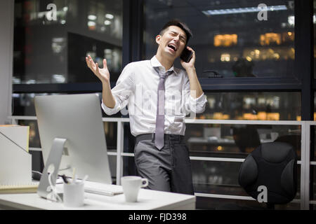 Chinese businessman working late in office Stock Photo