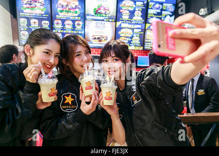 Members of staff take a selfie during the pre-opening event for the Japan's first Carl's Jr. burger restaurant located in Tokyo's Akihabara district, on March 2, 2016, Japan. The Californian fast food restaurant follows on the heels of Shake Shack in entering the Japanese market. Mitsuuroko Group Holdings Co., Ltd. has signed a franchise agreement to operate Carl's Jr. branches in Japan with the first to open to the public on March 4th. © Rodrigo Reyes Marin/AFLO/Alamy Live News Stock Photo