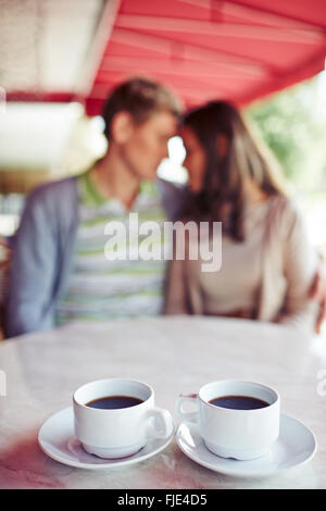Two cups of coffee with couple in the background Stock Photo