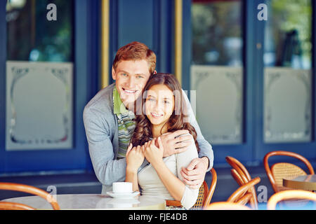 Affectionate couple sitting in café and embracing Stock Photo
