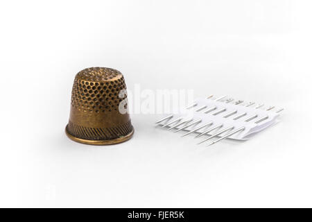 Thimble and needles on white background Stock Photo