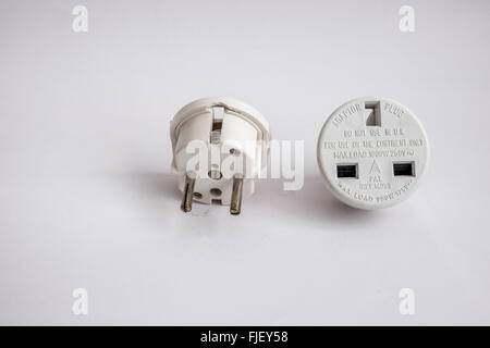 Mains adapter plug with 13 amp 3 pin socket converted to 2 round pins for use in Europe. Stock Photo