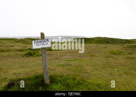 St Agnes, Cornwall, UK. Sign warning hikers of the dangers of low-flying golf balls. Stock Photo