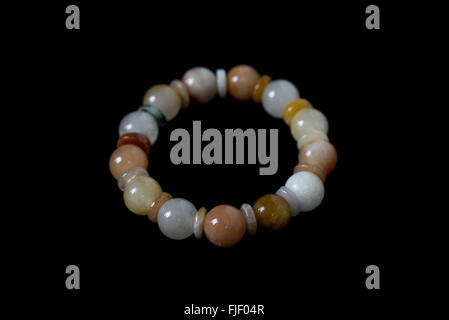 Lucky stone bracelet isolated on black background. Stock Photo