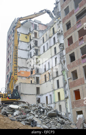 An excavator from a demolition company razes a Plattenbau building from the German Democratic Republic at Juri Gagarin Ring 10 through 16 in Neubrandenburg, Germany, 02 March 2016. The eleven-story apartment house has around 11,000-square-meters of living space. The demolition of the building, built in 1974 with 199 apartments, should be finished at the end of May 2016. The demolition costs are being financed in part by the support of the State of Mecklenburg-Western Pomerania for the stabilization of the housing market through demolition in designated development areas. Photo: Stefan Sauer/d Stock Photo