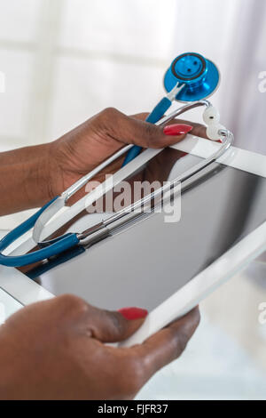 Close-up Of Doctor Using  Digital Tablet At Desk Stock Photo