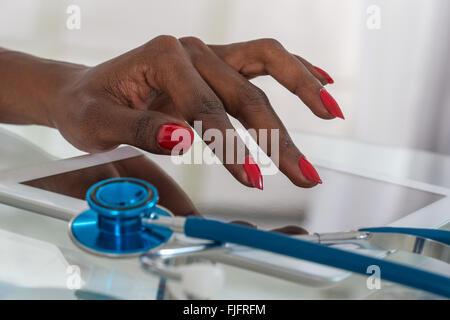 Close-up Of Doctor Using  Digital Tablet At Desk Stock Photo