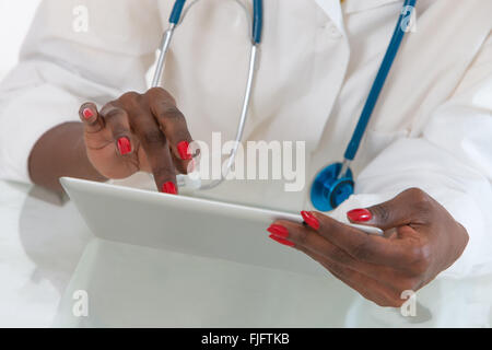Close-up Of Doctor hans  on  Digital Tablet At Desk with stethoscope Stock Photo
