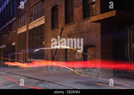 Water Street at night in the waterfront neighborhood of DUMBO in Brooklyn at night with car tail light light trails Stock Photo
