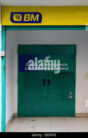 Emergency exit written on door in both Spanish and Basque languages, Bilbao, Basque Country, Spain Stock Photo