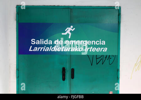 Emergency exit written on door in both Spanish and Basque languages, Bilbao, Basque Country, Spain Stock Photo