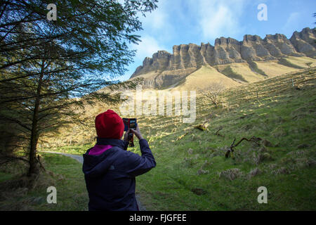 Woman takes a photo of Benbulben in Ireland with her phone Stock Photo