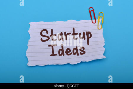 Startup Idea written on paper with blue background. Stock Photo