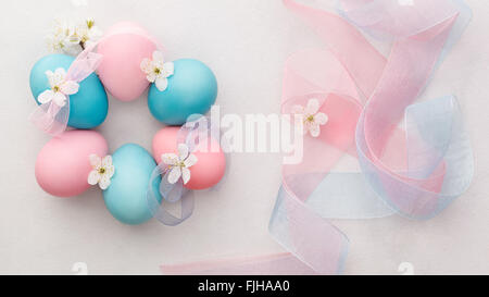 Naturally dyed Easter eggs. Six pastel colored eggs on light background with ribbon. Macro, selective focus, top view Stock Photo