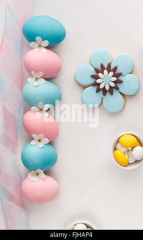 Easter eggs, candies and biscuits with pastel colored icing for Easter. Macro, selective focus, top view, blank space Stock Photo