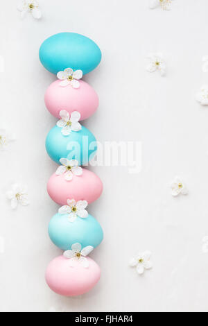 Naturally dyed Easter eggs. Six pastel colored eggs on light background with flowers Stock Photo