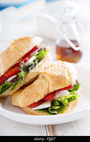 Croissant sandwich with brie, salad and strawberry Stock Photo