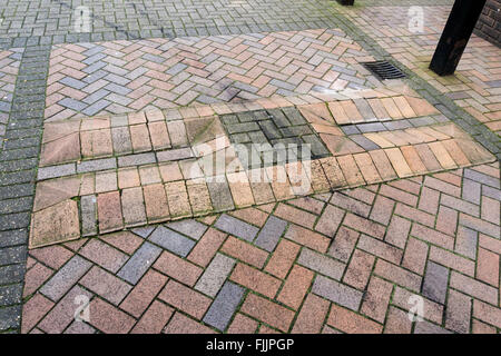 A sleeping policeman to slow traffic on a brick paved estate road. Stock Photo
