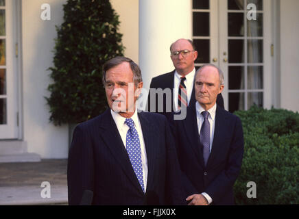 Washington, DC., USA,  1990 President George H.W. Bush talks with reporters in the Rose Garden as National Security Adviser Brent Scrowcroft  and press secretary Marlin Fitzwater look on.  Credit: Mark Reinstein Stock Photo