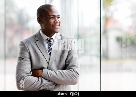 handsome black businessman looking outside window Stock Photo