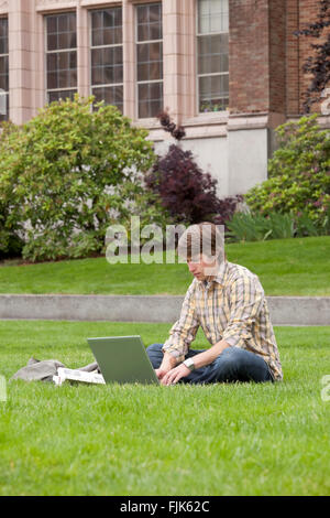 Male college student studying with laptop computer and books on university campus Stock Photo