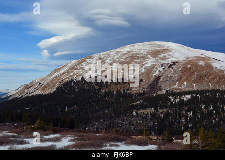 Strange Lenticular Clouds Over a Snow Covered Mountain Top Stock Photo
