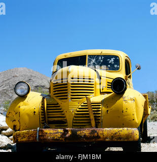 An yellow abandoned vehicle Bonnie and Clyde style.Against a clear blue sky Stock Photo
