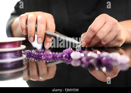 Corals, purple marble. Amethyst, a beautiful purple necklace. Threading beads, jewelry workshop Stock Photo