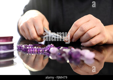 Corals, purple marble. Amethyst, a beautiful purple necklace. Threading beads, jewelry workshop Stock Photo