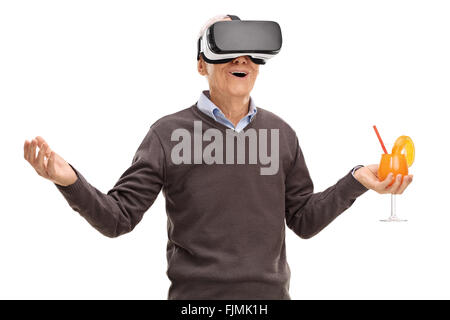 Senior using a VR headset and holding an orange cocktail isolated on white background Stock Photo