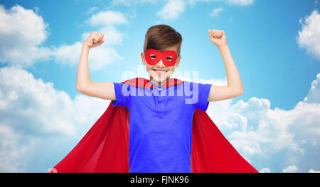 boy in red super hero cape and mask showing fists