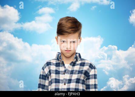 angry boy in checkered shirt over blue sky Stock Photo