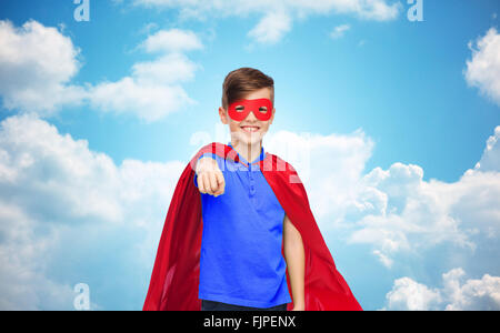 happy boy in red superhero cape and mask Stock Photo