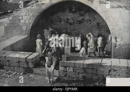 Young girls taking water from the well  in 1930s in the Holy Land   - not very different from biblical times Stock Photo