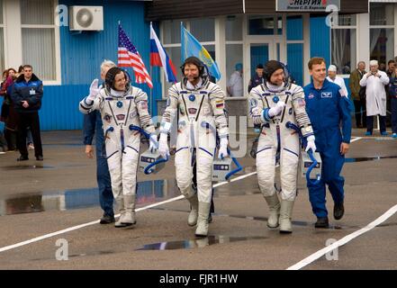 International Space Station Expedition 19 crew wave as they walk out to board the Soyuz TMA-10 spacecraft ahead of launch March 26, 2009 in Baikonur, Kazakhstan. Crew includes: Commander Russian cosmonaut Gennady Padalka, center, space tourist Charles Simonyi, left, and NASA astronaut Michael Barratt. Stock Photo