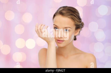 woman smelling perfume from wrist of her hand Stock Photo