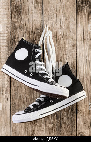 Black sneakers shoes on wooden background. Stock Photo