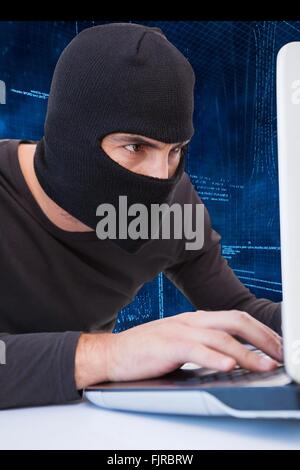 Hacker using laptop Stock Photo