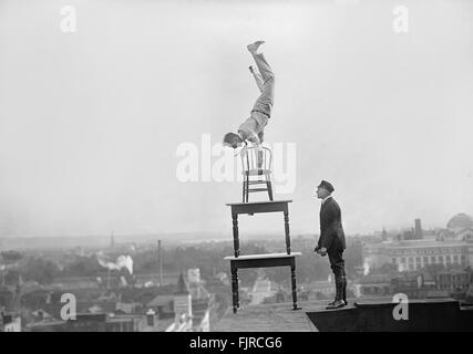 Jug Reynolds Performing Daredevil Balancing Act on High Cornice above Ninth Street N.W. Washington DC, USA, 1917 Stock Photo